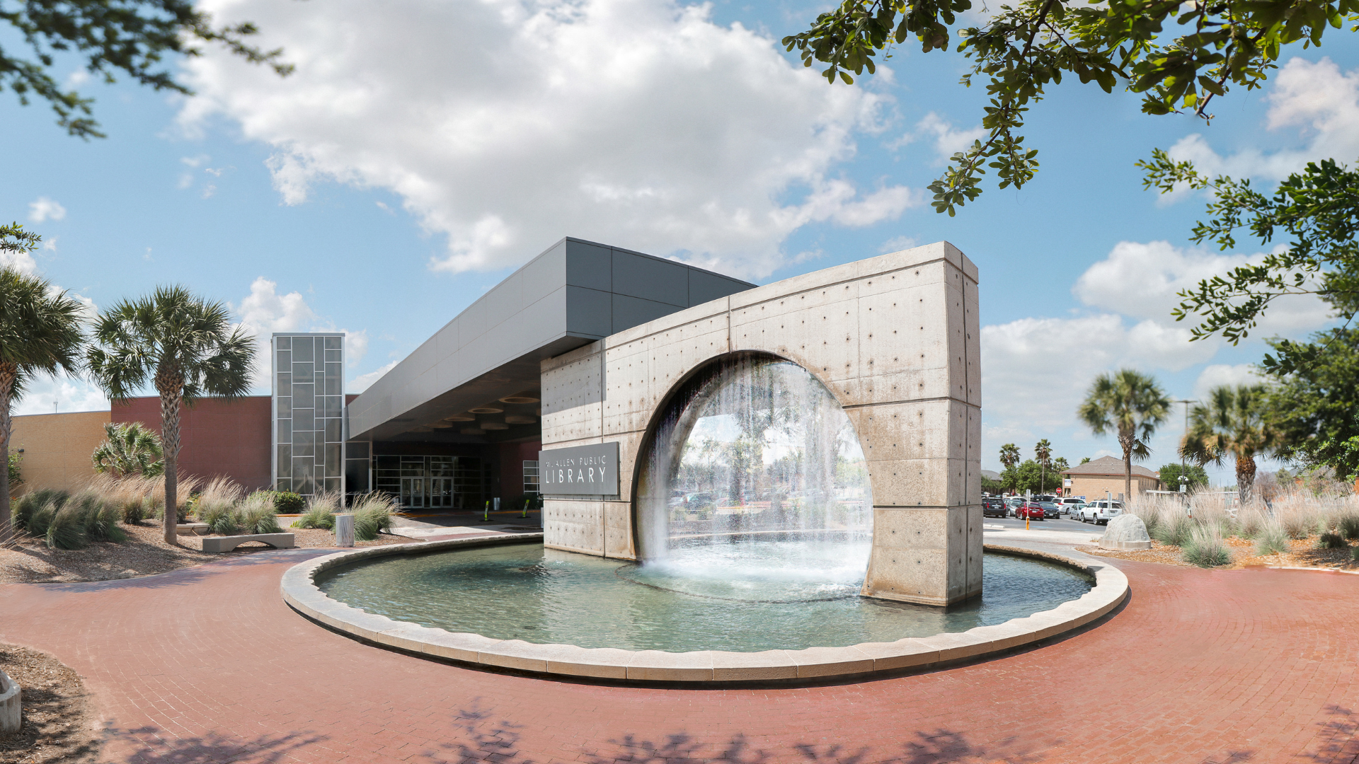 Exterior view of Main Library featuring the iconic circular fountain at the entrance on a sunny day.